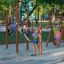 Outdoor playground Pull up bars with children exercising and playing on wooden fitness equipment.