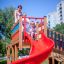Children playing on the red slide of the Space Station castle.