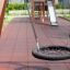 Single Swing (BNS 90cm) round net swing on playground with safety flooring and climbing structure in