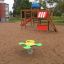 Children's playground with Climbing Booth structure and spring rider on sandy ground.