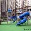 Playground Citadel castle with slide amidst apartment buildings.