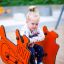 Child playing on Bulldozer rocking in a playground.