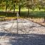 Climbing net pyramid frame at a playground surrounded by trees.