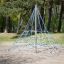 Small Powerclimber climbing net in a park with trees in the background.