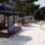 Playground equipment including Clover Table at a sandy outdoor location.