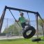 Boy swinging on Double Tyre double swing in the playground.