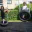 Children playing on a Double Tyre double swing in a garden.