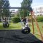 Children playing on a Double Tyre double swing in a playground.