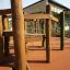 Wooden outdoor playhouse for children, perfect for playgrounds and parks.