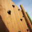 Wooden wall of Spillikins wooden playhouse with climbing holds.