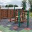 Spillikins wooden playhouse on playground with climbing structures and rubber safety flooring.