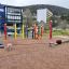 Colorful Crayons wooden playhouse at a playground with various equipment in the background.