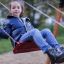Children enjoying a Double Safety Seat double swing in a park.