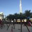 Double Safety Seat double swing on playground with Burj Khalifa in background.