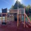 Wooden Climbing Booth Nature playhouse with slide and climbing features on a playground.