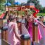 Two girls playing in Ariadne playground maze structure with a slide in the background.