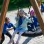Children playing on a Triple swing at a playground.