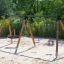 Triple swing on a playground with sand.