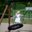 Child playing on a Triple swing in a park.