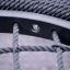 Close-up of Triple swing play equipment highlighting black ropes and a metal frame.