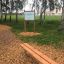 Wooden bench with steel legs in a park.