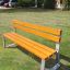 Tallin Bench w/ Backrest in a grassy park area.