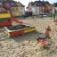 Sandbox with colorful side panels in a children's playground'
