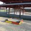 Sandbox in a playground with a wooden structure in the background