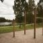 Outdoor Pull Bars for workout in a park area with trees and a lake in the background.