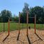 Outdoor Pull Bars in a playground with a woodchip surface.