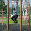 Woman exercising on Pull Bars in an outdoor gym.