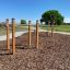 Outdoor workout station Bars I with wooden beams and metal bars in a park setting.
