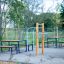 Outdoor fitness station Bars II with surrounding benches in a park.