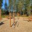 Wooden outdoor fitness equipment Bars II in a forest setting.
