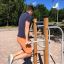 Man using the Bars II outdoor workout equipment for upper body exercise.