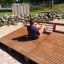 Sit-ups Bench in an outdoor fitness area with a man exercising.