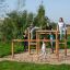 Children playing on Over–under playground equipment in a park.