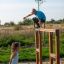 Children playing on Overâ€under wooden playground structure outdoors.