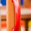 Vertical wooden ladder with red handle grip