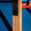 Vertical wooden ladder with metal brackets in playground.