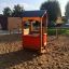 Outdoor 'Playhouse' play structure in a sandy playground.