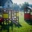 Playhouse in a playground with slides and climbing structures.