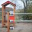 Wooden playhouse with colorful spinning bars in a playground.