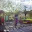 Child playing at Playhouse playground equipment set in a park.