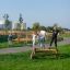 Children and adults balancing on Balancer outdoor playground equipment.