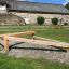 Wooden outdoor Balancer playground equipment on a gravel surface.