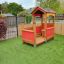 Veranda House single playhouse on a grass playground with red panels and wooden structure.