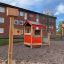 Veranda House single playhouse in a playground with birdhouses and apartment buildings in the backgr