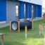 Magnifying glass for children on playground with wooden climbing frames and tunnel.