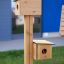 Bird feeder with two wooden birdhouses mounted on a vertical post.